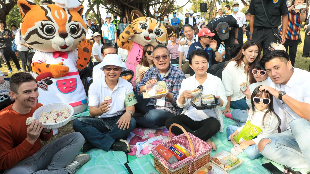 台中市長盧秀燕在中央公園現身示範野餐,將籃中滿滿的零食分送給小朋友,鼓勵市民一年365天都可到戶外走走。(圖/台中市政府)