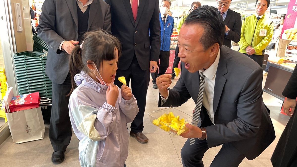 嘉義縣長翁章梁在大分縣新鮮市場擔任試吃推銷員,讓小朋友品嚐嘉義鳳梨。(圖/嘉義縣政府農業處提供) 嘉義縣長翁章梁在大分縣新鮮市場擔任試吃推銷員,讓小朋友品嚐嘉義鳳梨。(圖/嘉義縣政府農業處提供)