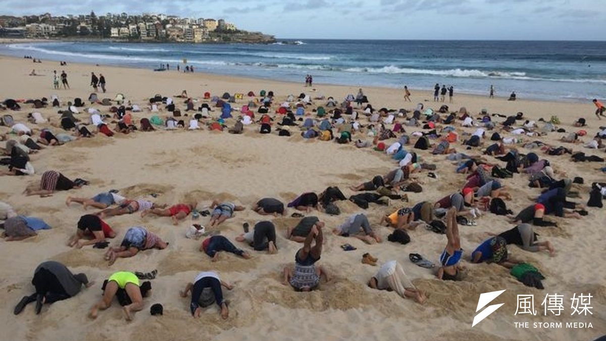 一群民眾13日聚集在雪梨的邦迪海灘,將頭埋入沙中,抗議澳洲政府對全球暖化危機視而不見。(取自網路) 一群民眾13日聚集在雪梨的邦迪海灘,將頭埋入沙中,抗議澳洲政府對全球暖化危機視而不見。(取自網路)