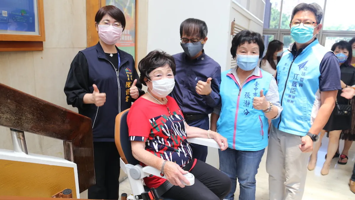 台中在地企業羅布森公司特別2座樓梯升降椅給葫蘆墩文化中心,讓行動不便的民眾和長者方便參觀,86歲鄧彩雲阿媽試作體驗與局長陳佳君、董事長汪世旭合影。(圖/台中市政府提供)