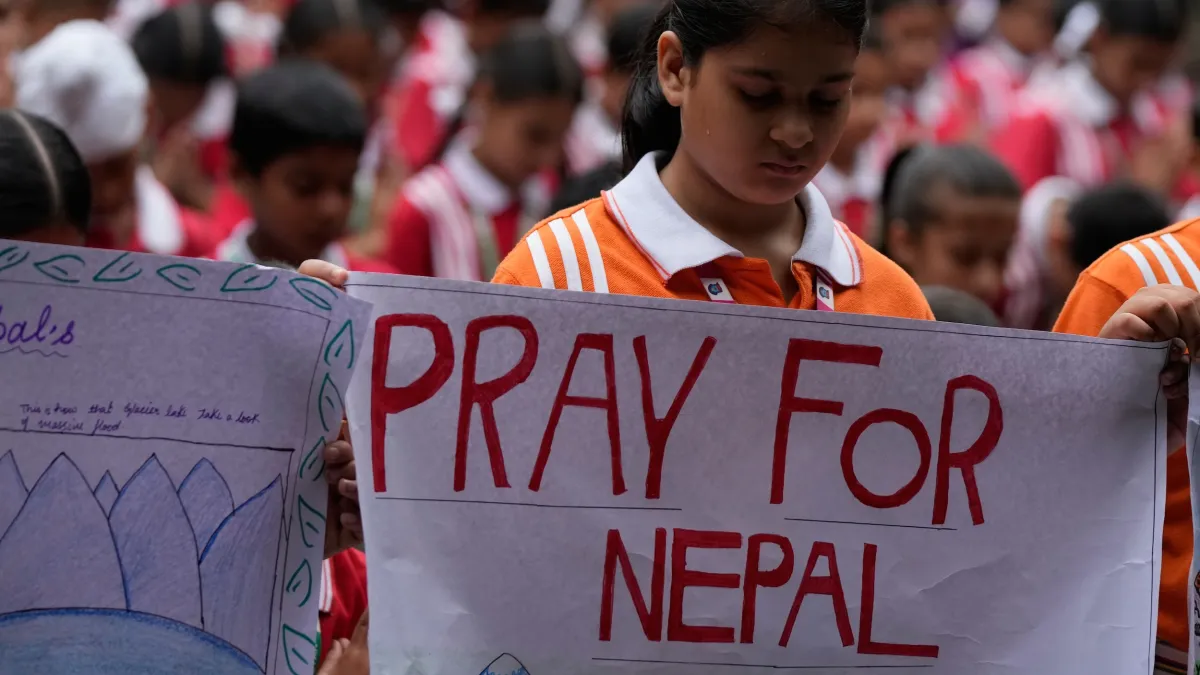 Students in Jammu, India, hold placards in prayer for victims of the August 26 flash flood that devastated communities along the Nepal-China border, killing more than 800 people. (AP)