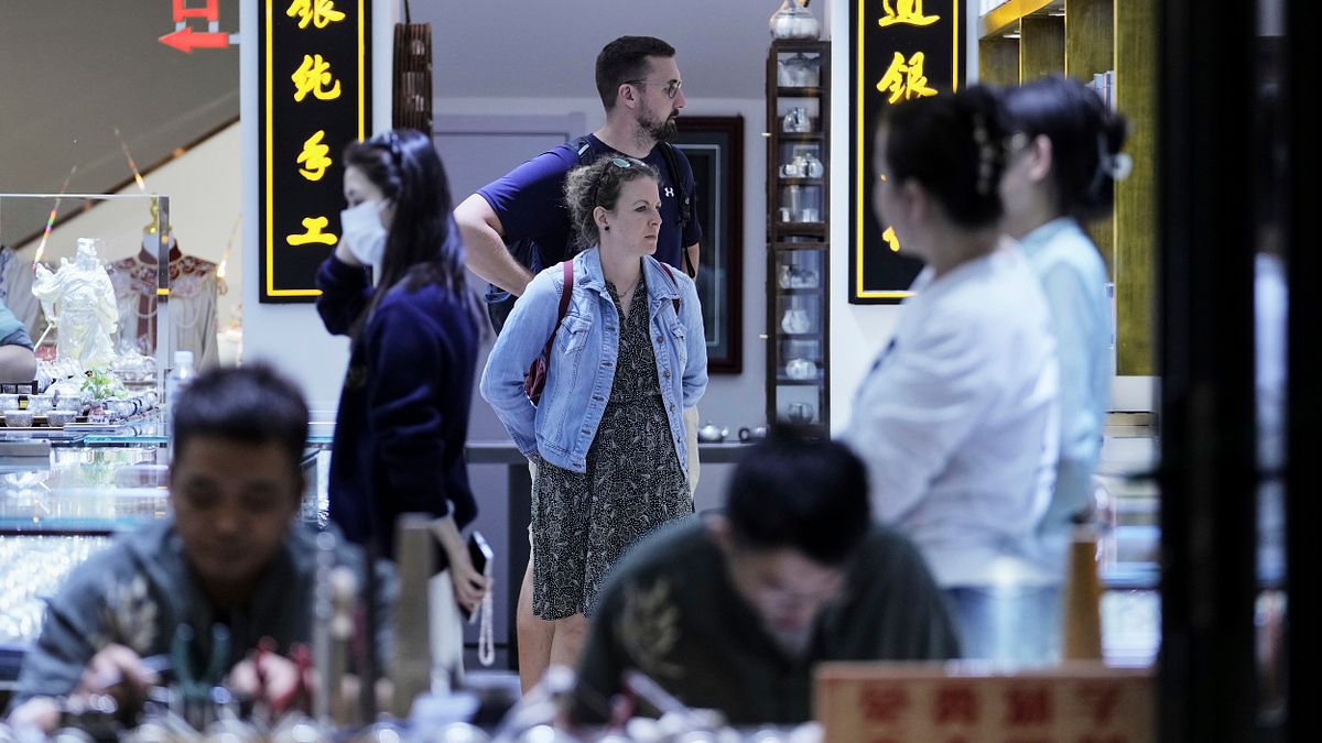 2025年4月27日,一對遊客情侶在北京購物街上一家紀念品商店。(美聯社) 2025年4月27日,一對遊客情侶在北京購物街上一家紀念品商店。(美聯社)