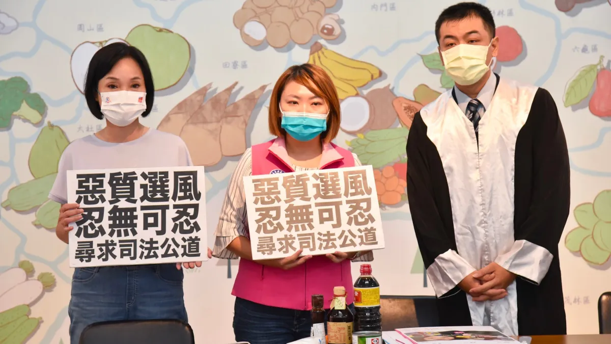 高雄市議員邱于軒在高雄市長候選人柯志恩陪同下,手執標語將尋求司法公道。(圖/柯志恩辦公室提供)
