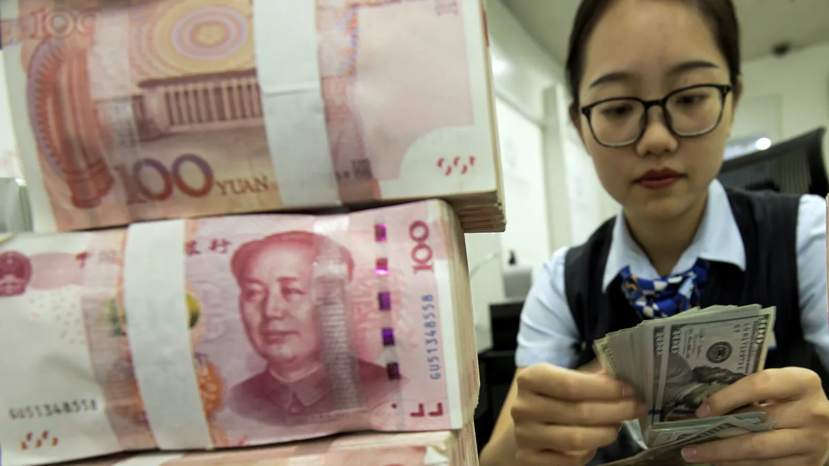 中国銀行の行員が人民元と米ドルの紙幣を数える。(写真/AP通信)