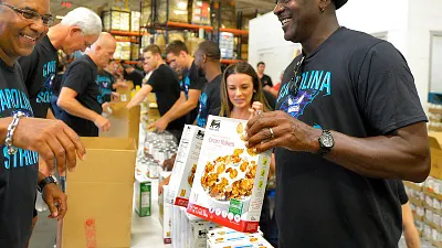 黃蜂老闆喬丹(右)親自為風災災民打包食物。(美聯社)