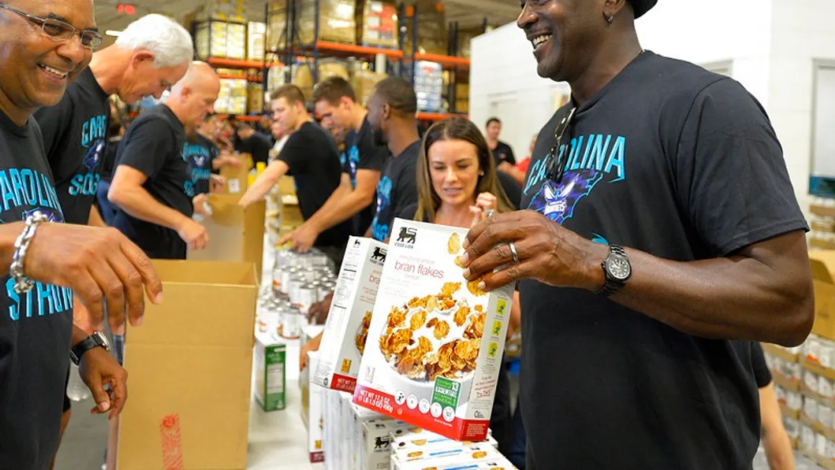 黃蜂老闆喬丹(右)親自為風災災民打包食物。(美聯社)