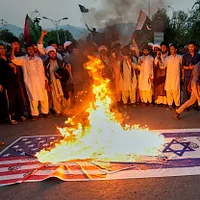 2025年6月17日、パキスタンのイスラマバード(Islamabad)で、シーア派ムスリムがイスラエルによるイラン空襲に抗議し、アメリカとイスラエルの旗の模型を焼く。(AP通信) 2025年6月17日、パキスタンのイスラマバード(Islamabad)で、シーア派ムスリムがイスラエルによるイラン空襲に抗議し、アメリカとイスラエルの旗の模型を焼く。(AP通信)