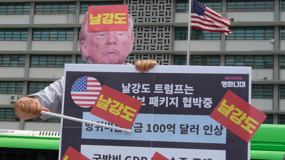 2025年7月30日、韓国ソウルのアメリカ大使館前にて、トランプのマスクを着けた韓国の抗議者が「強盗」と書かれたプラカードを掲げ、トランプの対韓関税政策に抗議している。(写真/AP通信提供) 2025年7月30日、韓国ソウルのアメリカ大使館前にて、トランプのマスクを着けた韓国の抗議者が「強盗」と書かれたプラカードを掲げ、トランプの対韓関税政策に抗議している。(写真/AP通信提供)