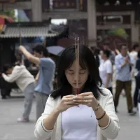 一位年輕女子在寺廟祈福。(Gilles Sabrié for WSJ) 一位年輕女子在寺廟祈福。(Gilles Sabrié for WSJ)