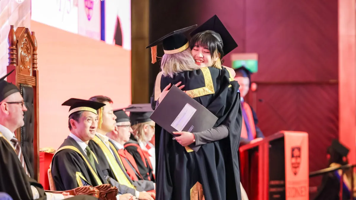 澳洲雪梨大學的畢業典禮,學生與教授相擁道別。(取自學校官方粉專)