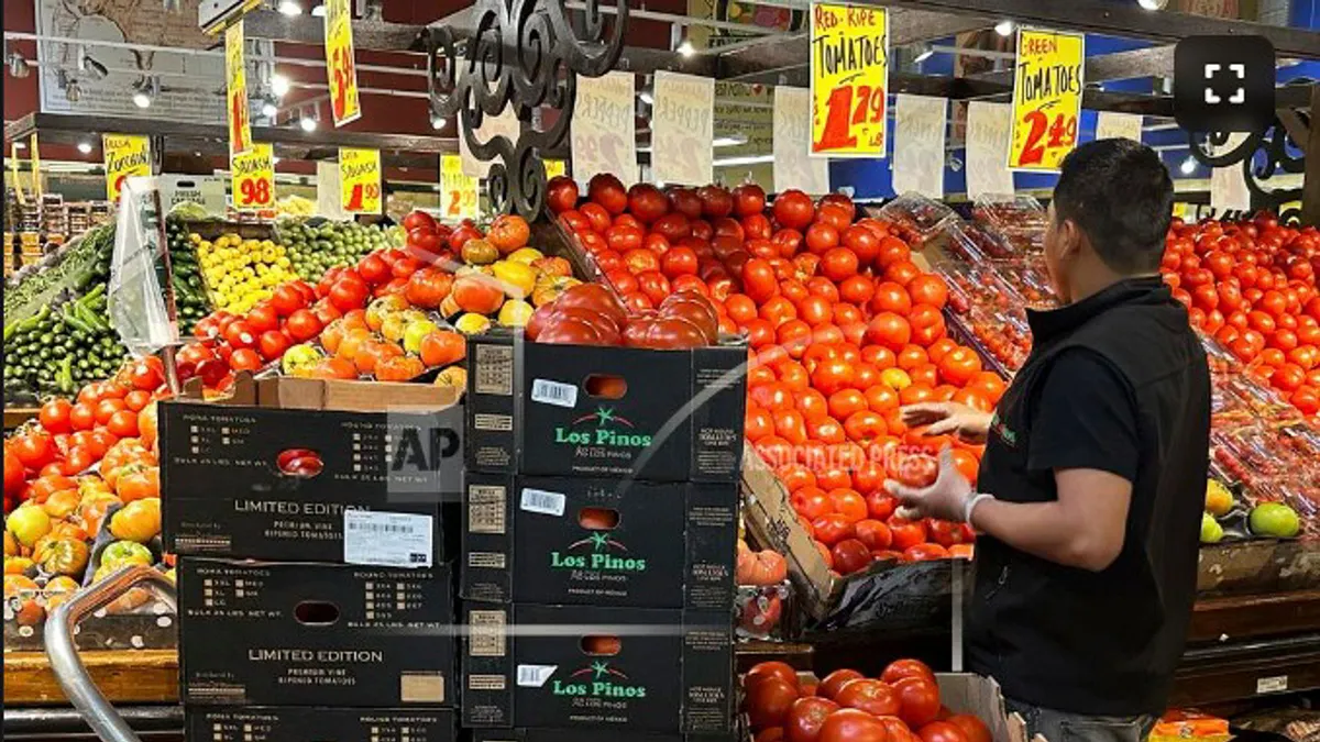 美國超市員工將新的番茄搬上貨架。(美聯社) 美國超市員工將新的番茄搬上貨架。(美聯社)