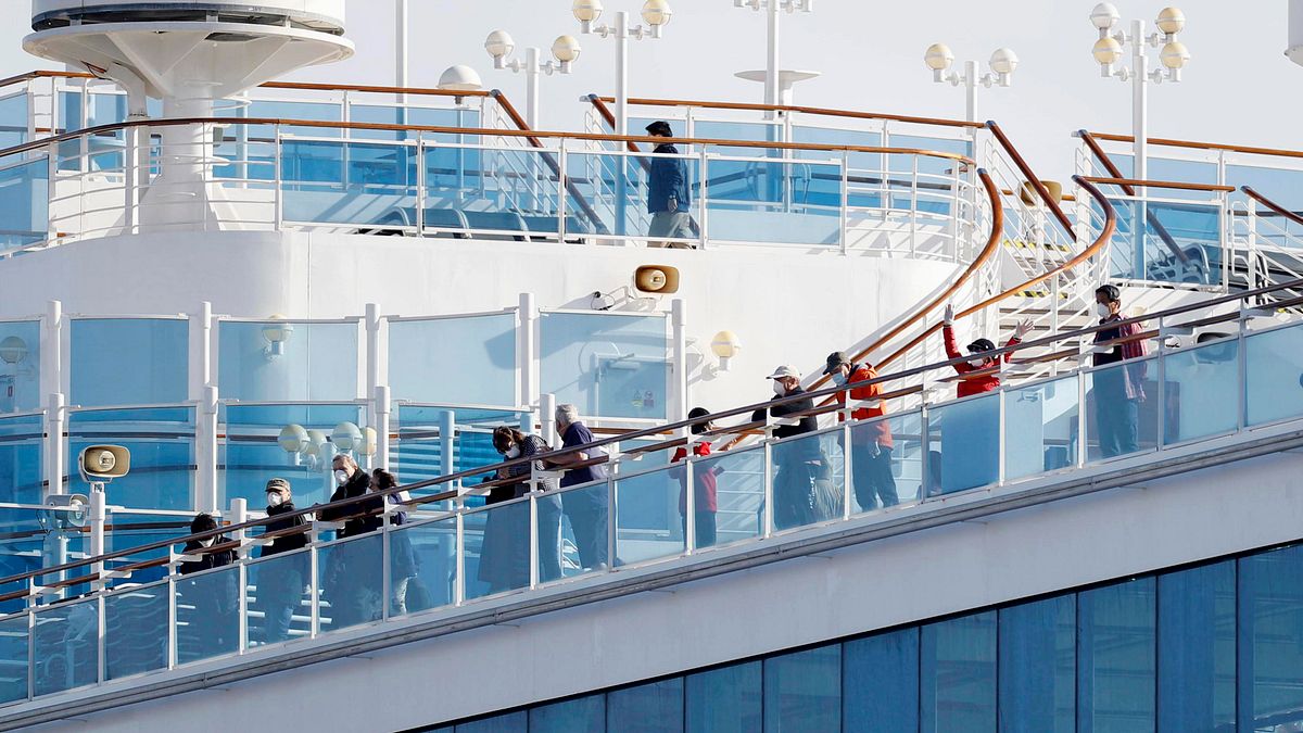 因多人群聚感染、停泊日本遭隔離的郵輪「鑽石公主號」,乘客在甲板上向下張望。(AP) 因多人群聚感染、停泊日本遭隔離的郵輪「鑽石公主號」,乘客在甲板上向下張望。(AP)