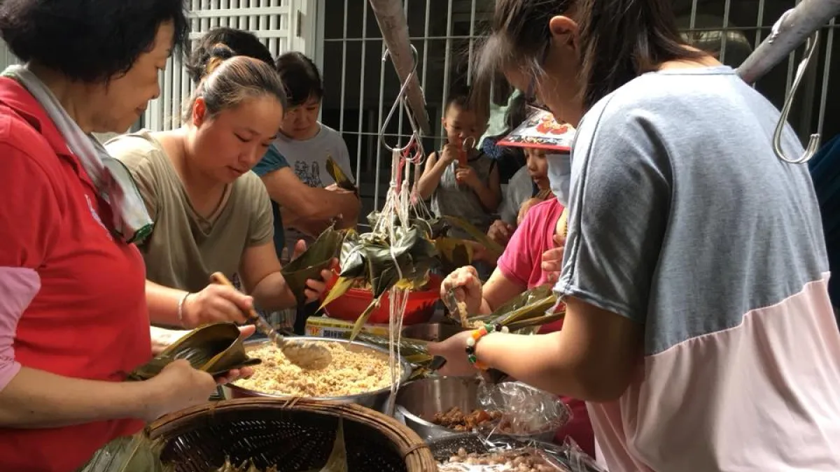 屏東縣單親母子家園(彩虹家園)舉辦「彩虹聚愛心、粽夏傳溫情」活動,單親媽媽帶著小朋友包肉粽,並親自送至獨居長輩家中,以實際行動關懷長輩,貢獻一己之力並傳遞愛心。(圖/屏東縣政府提供)