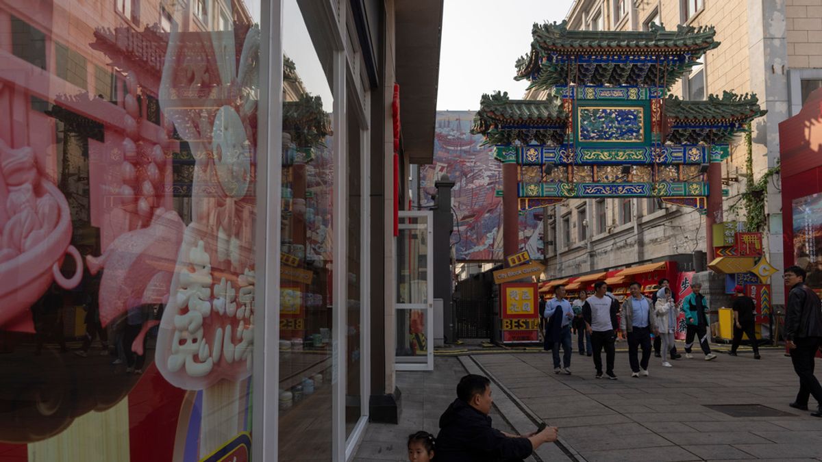 2024年11月1日。在北京廣受歡迎的王府井購物街,一個孩子在一名男子旁邊休息。(AP) 2024年11月1日。在北京廣受歡迎的王府井購物街,一個孩子在一名男子旁邊休息。(AP)