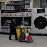 北京の街頭で、巨大なカセットテープのレプリカアートの前を台車を押して通り過ぎる清掃員(写真/AP通信提供) 北京の街頭で、巨大なカセットテープのレプリカアートの前を台車を押して通り過ぎる清掃員(写真/AP通信提供)
