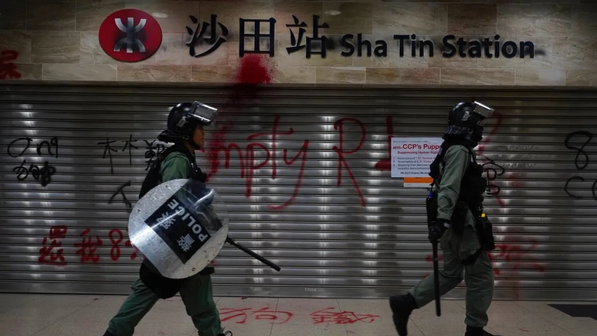 兩名香港警察在沙田站驅趕抗爭者。(美聯社)