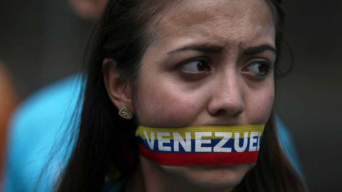 一位女性用委內瑞拉國旗顏色製成的布條封口,對政府表達無言的抗議。(美聯社) 一位女性用委內瑞拉國旗顏色製成的布條封口,對政府表達無言的抗議。(美聯社)