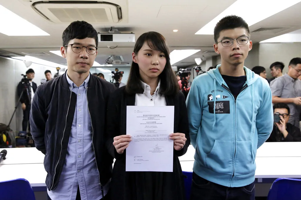 Demosisto founding members Nathan Law, Joshua Wong and Agnes Chow, from left, announced the party's dissolution on June 30, 2020, hours after Hong Kong's national security law took effect, the same period at the center of Wong's latest guilty plea. (AP)