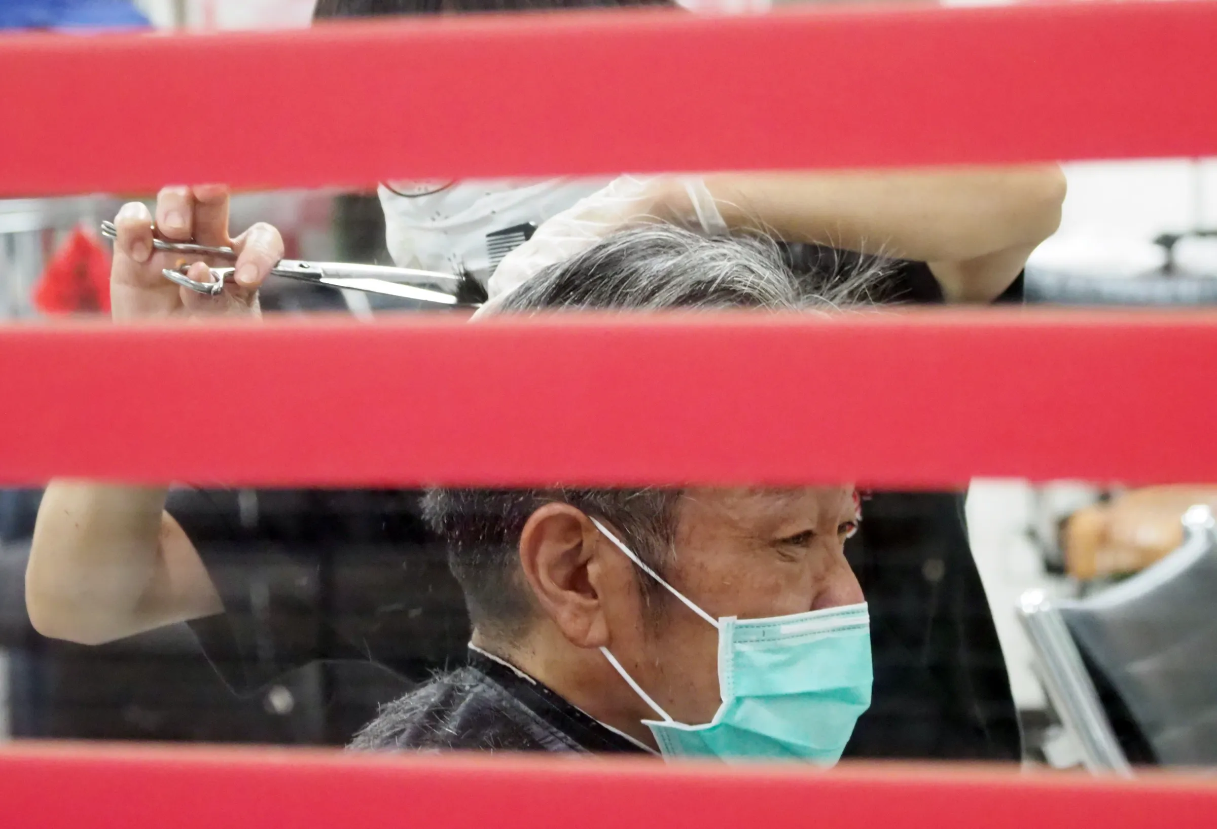20210630-新型コロナウイルスの影響で休業していた台北市龍山寺地下街が30日に営業を再開し、マスク姿の市民が地下街の理髪店を訪れた。（柯承恵撮影）
