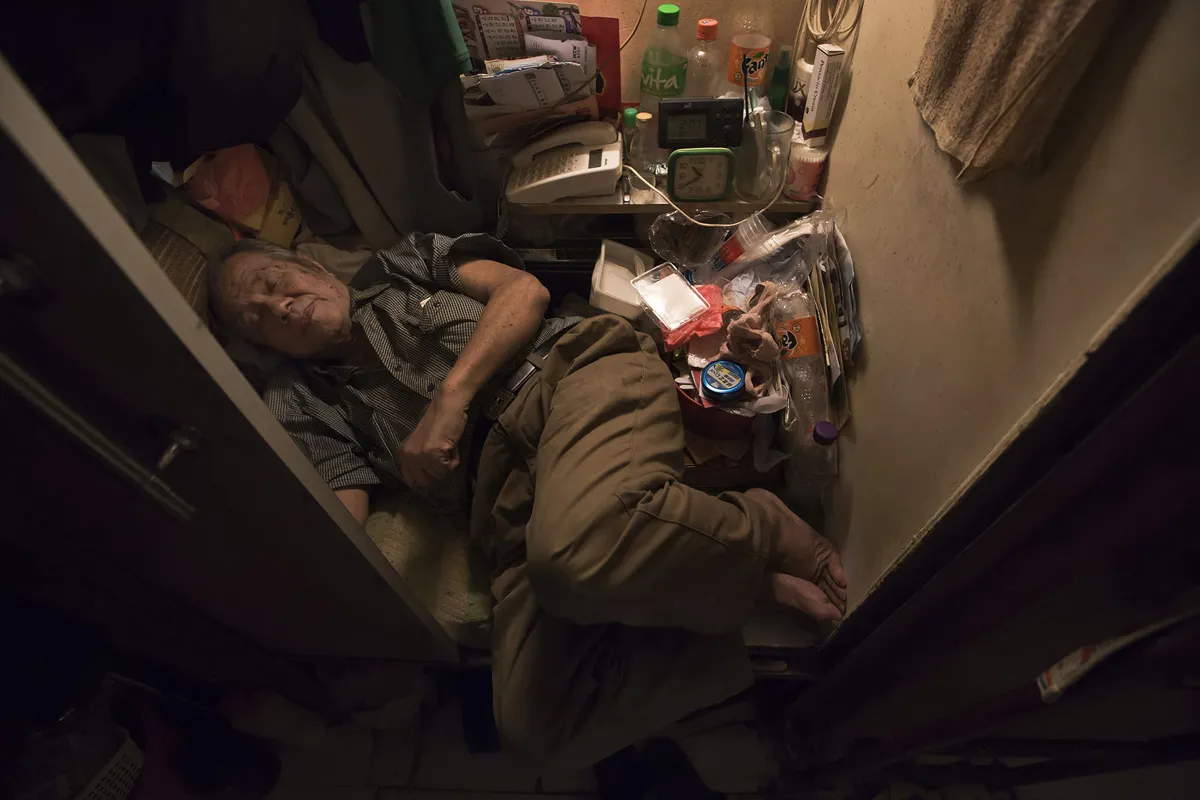 超過20萬香港人住在非法劏房裡，80歲的張先生睡在劏房裡，甚至無法將腳伸直（美聯社）