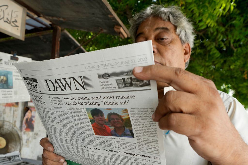 2023年6月21日、パキスタンの男性がカラチで「タイタン号」消息不明のニュースを読む。（AP通信）