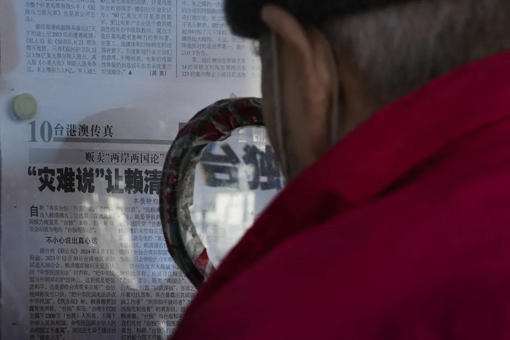 2024年1月3日，一位北京市民正在閱讀對於賴清德言論以及台獨的報導。（美聯社）