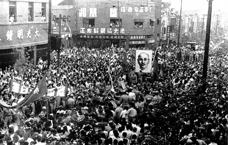 重慶遊行民眾高舉中美英蘇四國國旗與蔣介石像，力歡慶抗戰勝利。（國史館提供）