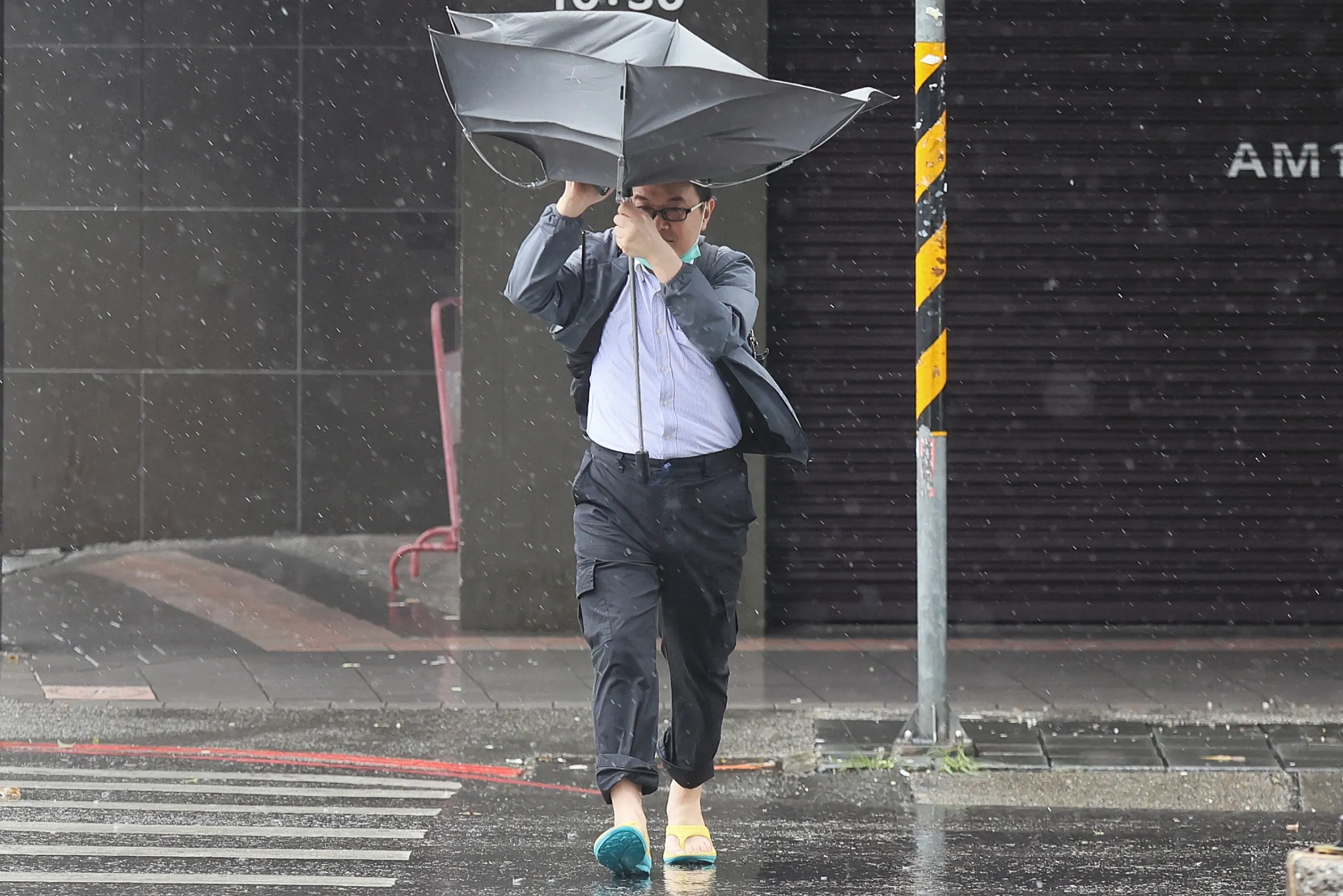 20241031-康芮颱風登陸台灣，颱風帶來的風雨把行人傘打歪了。（柯承惠攝）