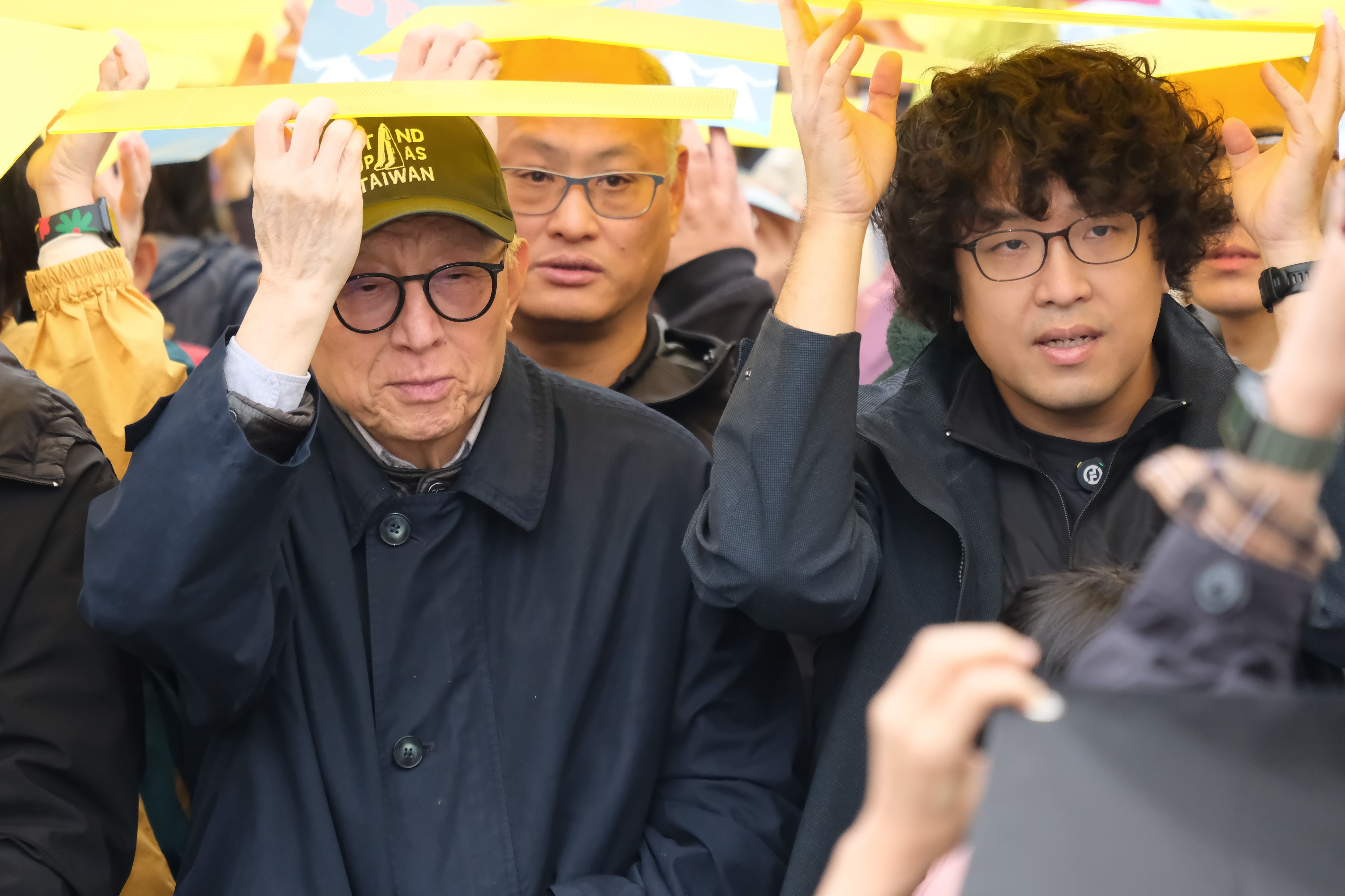 20241208-黑熊學院舉辦的「台灣主站派、接力護台灣」遊行8日抵達華山中央藝文公園，與民眾一起完成「DEFEND TAIWAN」千人排字，圖為民進黨立委沈伯洋（右）、聯電創辦人曹興誠（左）。（劉偉宏攝）