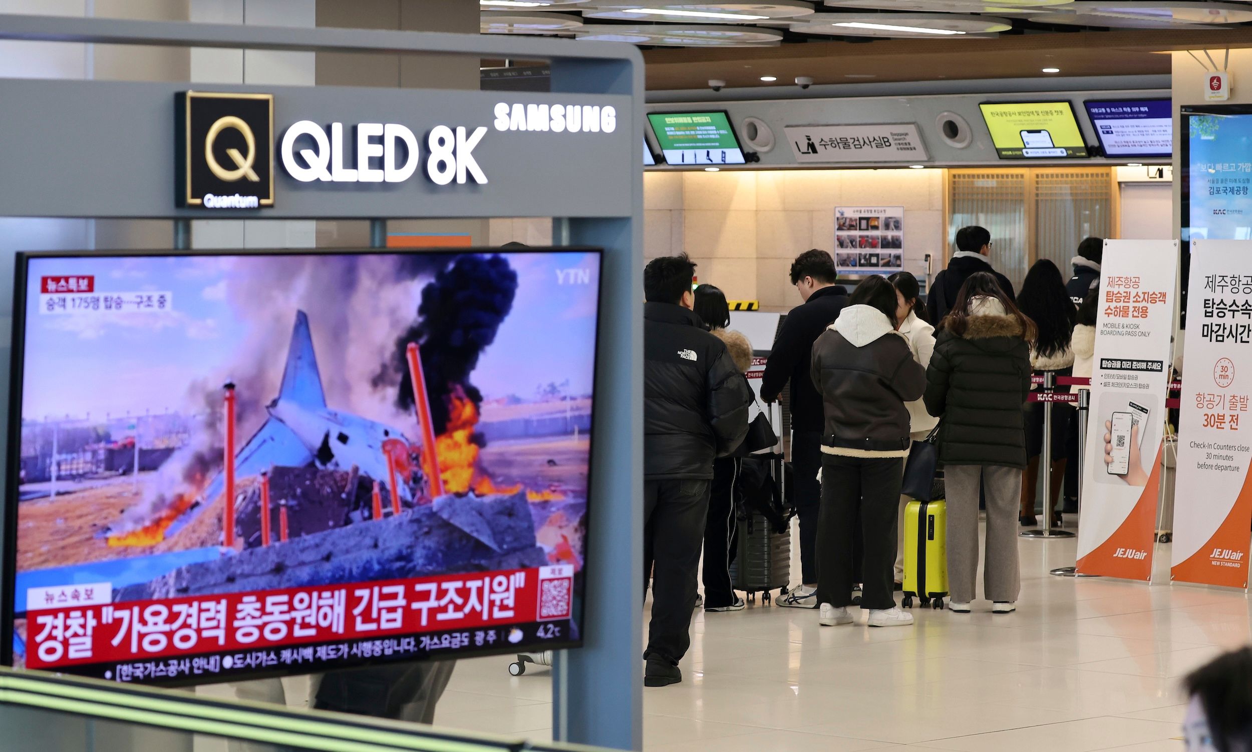 2024年12月29日，首爾金浦國際機場航空站的電視螢幕正在播報濟州航空空難的新聞。（美聯社）