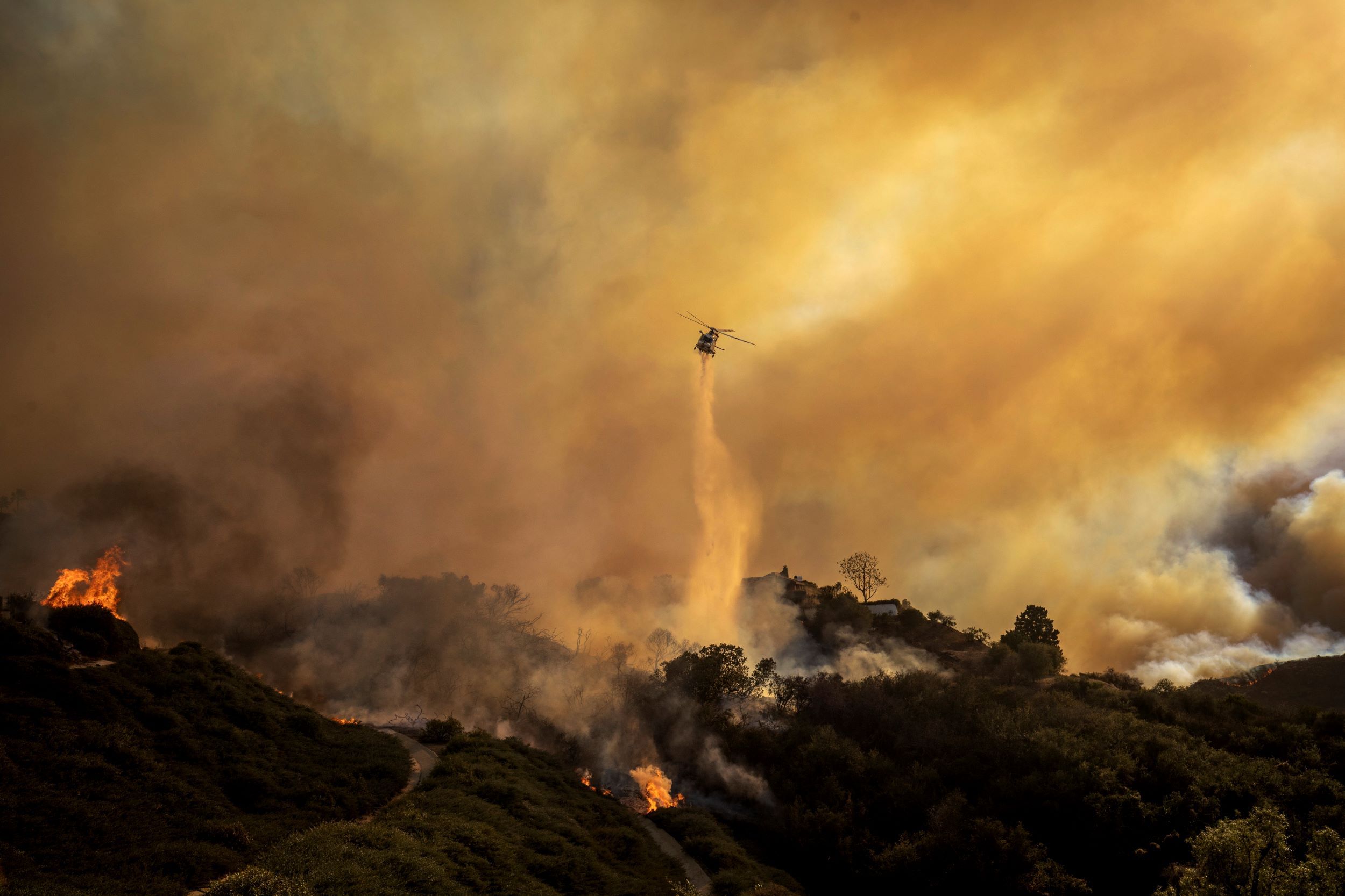 美國加州高級住宅區「太平洋帕利塞德」（Pacific Palisades ）發生嚴重大火，當地警消出動直升機協助滅火。（美聯社）