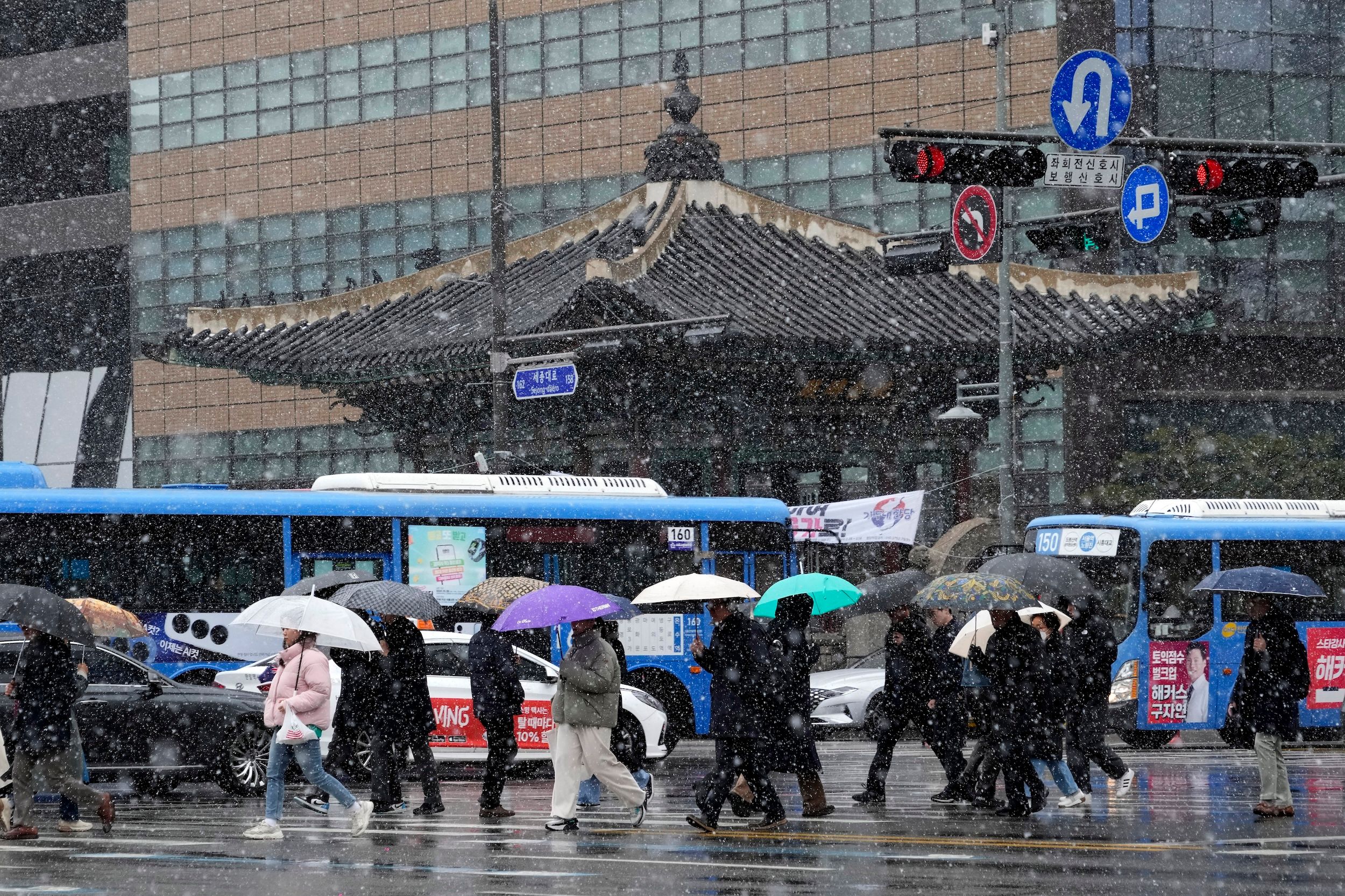 2025年3月4日，南韓首爾民眾在大雪中過馬路。（美聯社）