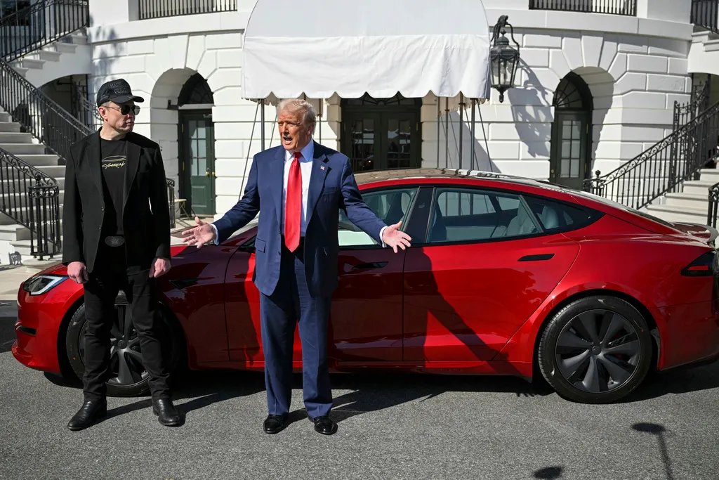 2025年3月11日。米国大統領トランプとテスラCEOマスクがテスラ車の前で記者と話す。（AP）