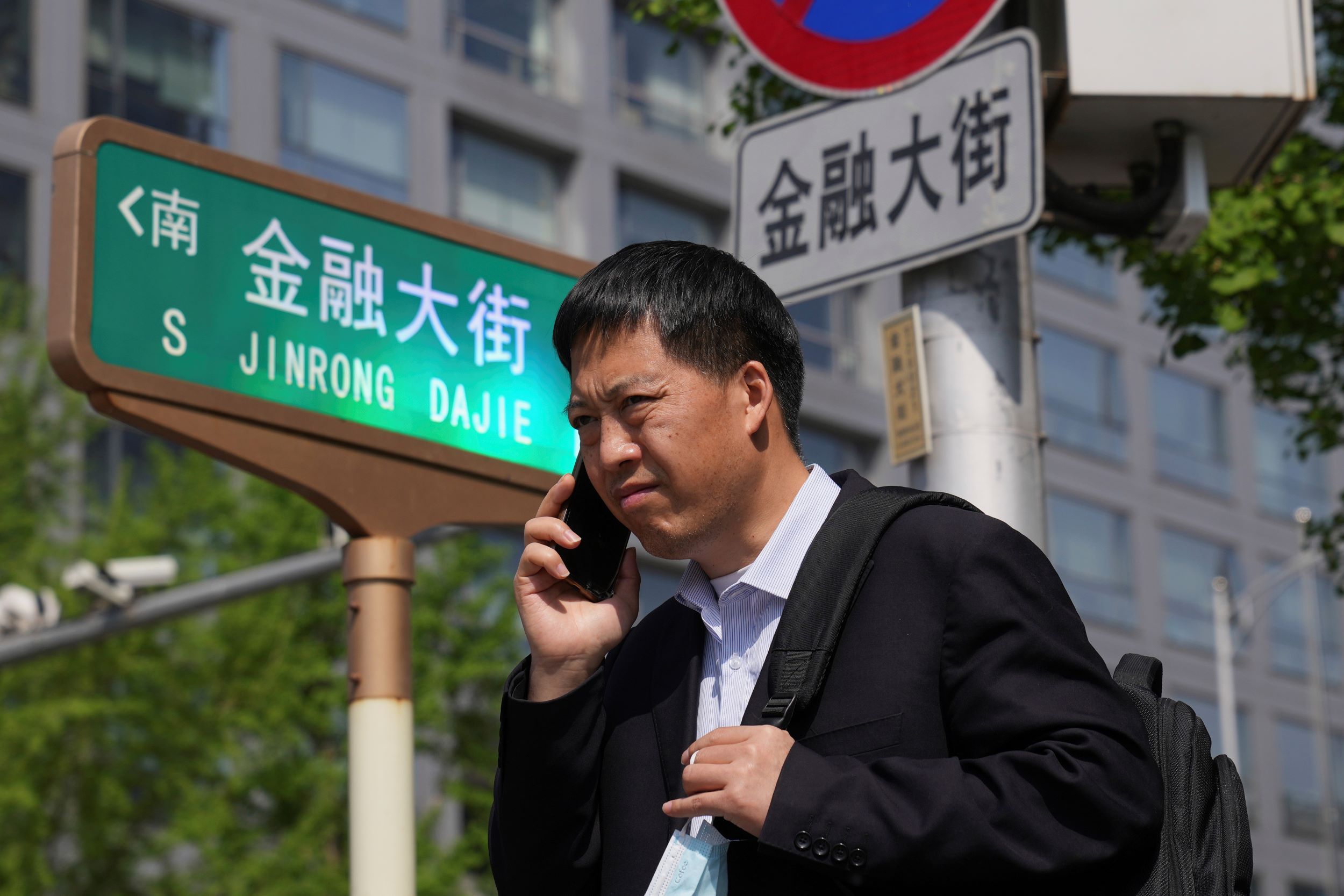北京上班族經過金融大街。（美聯社）