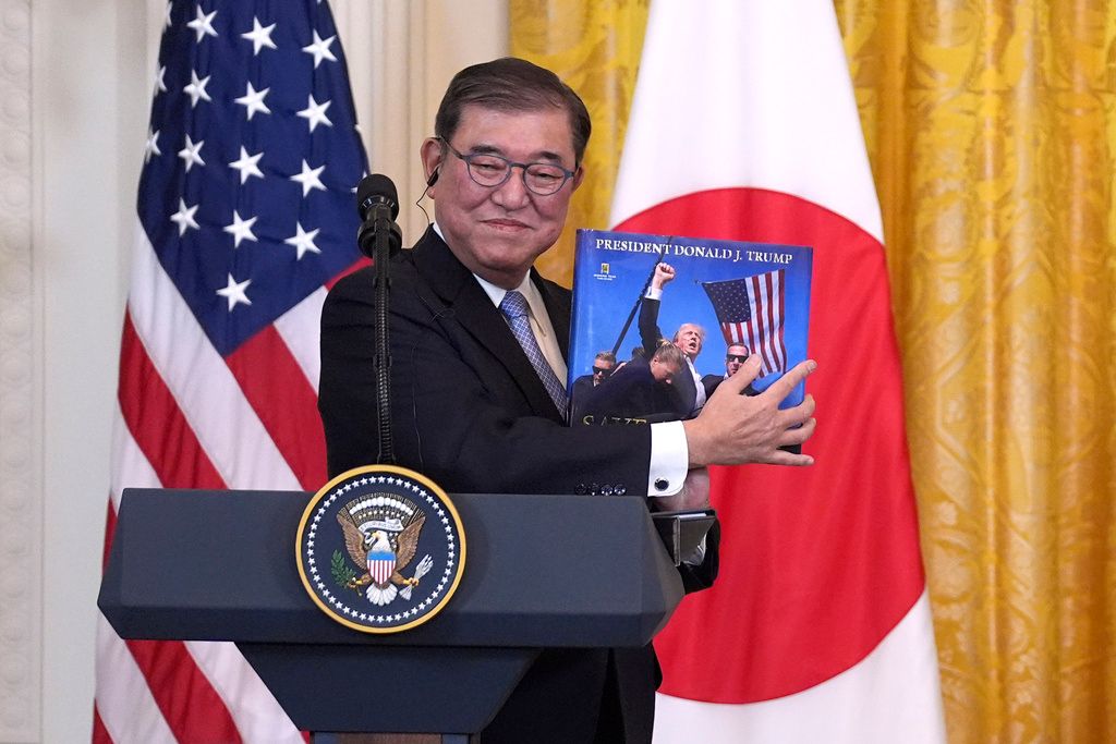 2025年2月7日。日本首相石破茂在白宮舉行的記者會上，拿著一本有關美國總統川普的書。（AP）