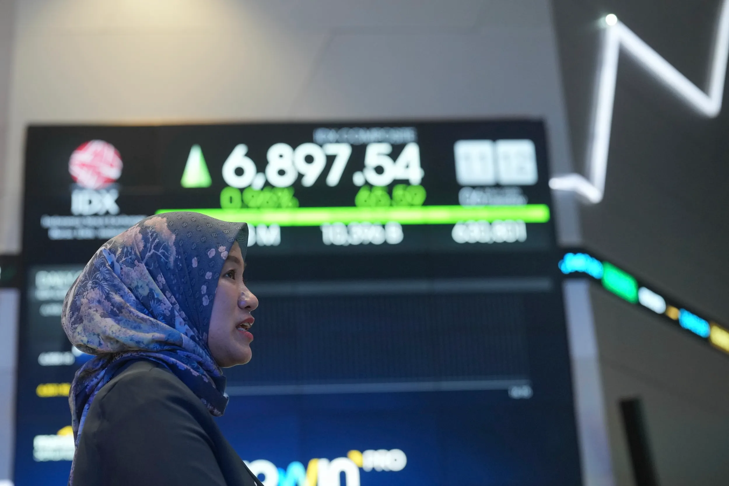 2025年5月6日，一位女性站在印尼雅加達印尼證券交易所內，螢幕上顯示著股票價格。（美聯社）