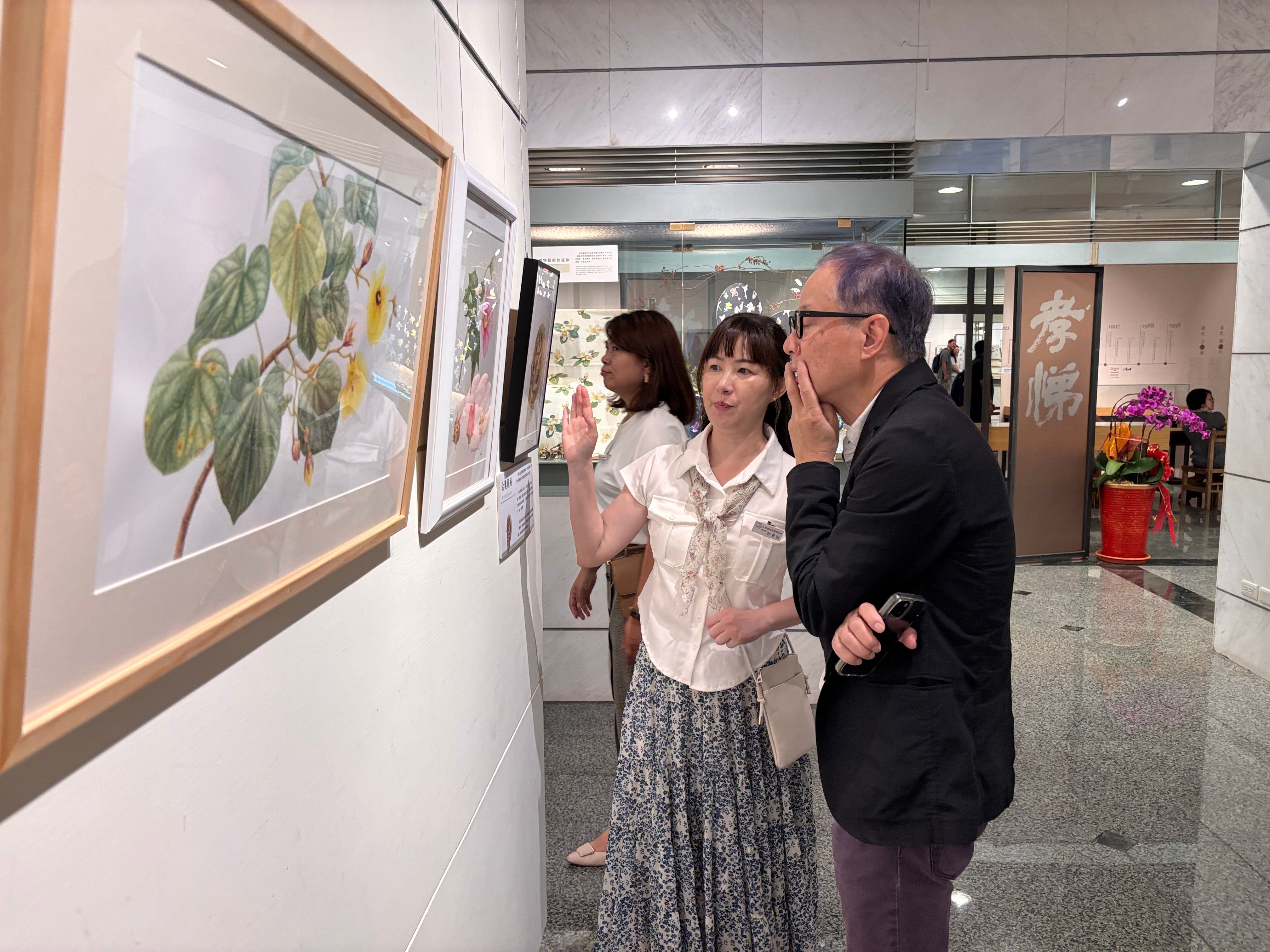 參展會員與來賓介紹展於成美藝廊的作品。(圖：頂新和德文教基金會提供)