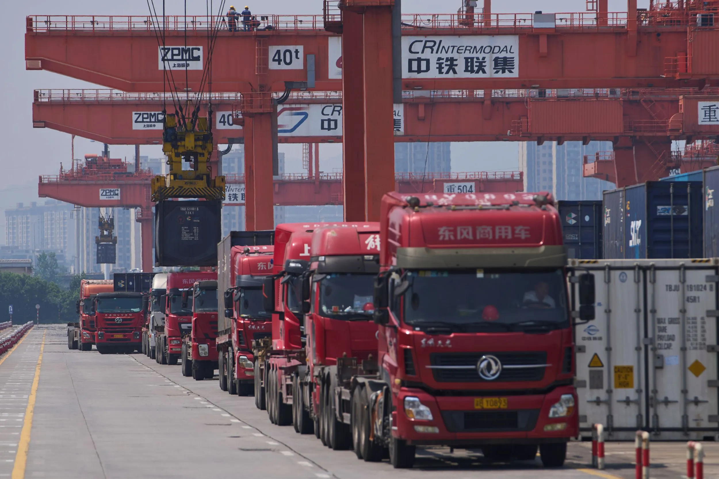 大量重型卡車停靠在中國重慶貨櫃碼頭。（美聯社）