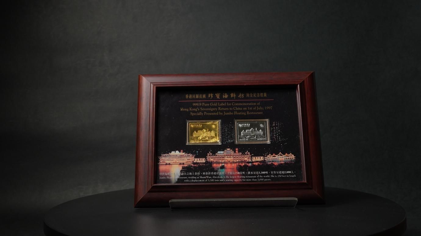 為紀念香港回歸而鑄造的珍寶海鮮舫純金銀紀念牌，背後正是2022年沉沒於南中國海的文化象徵。（作者提供）