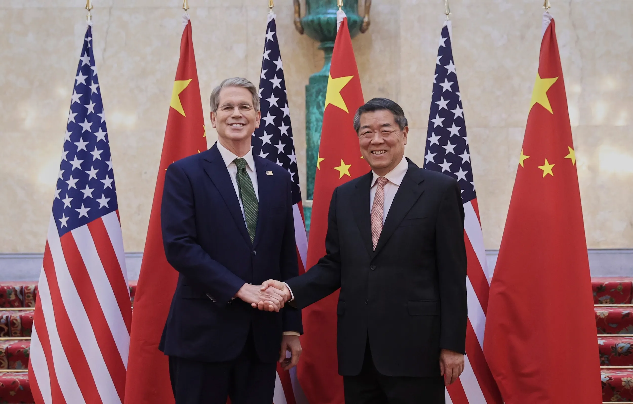 2025年6月9日、中国国務院副総理何立峰（右）がロンドンでアメリカ財務長官ベンセントと米中貿易会談前に握手。（美聯社）