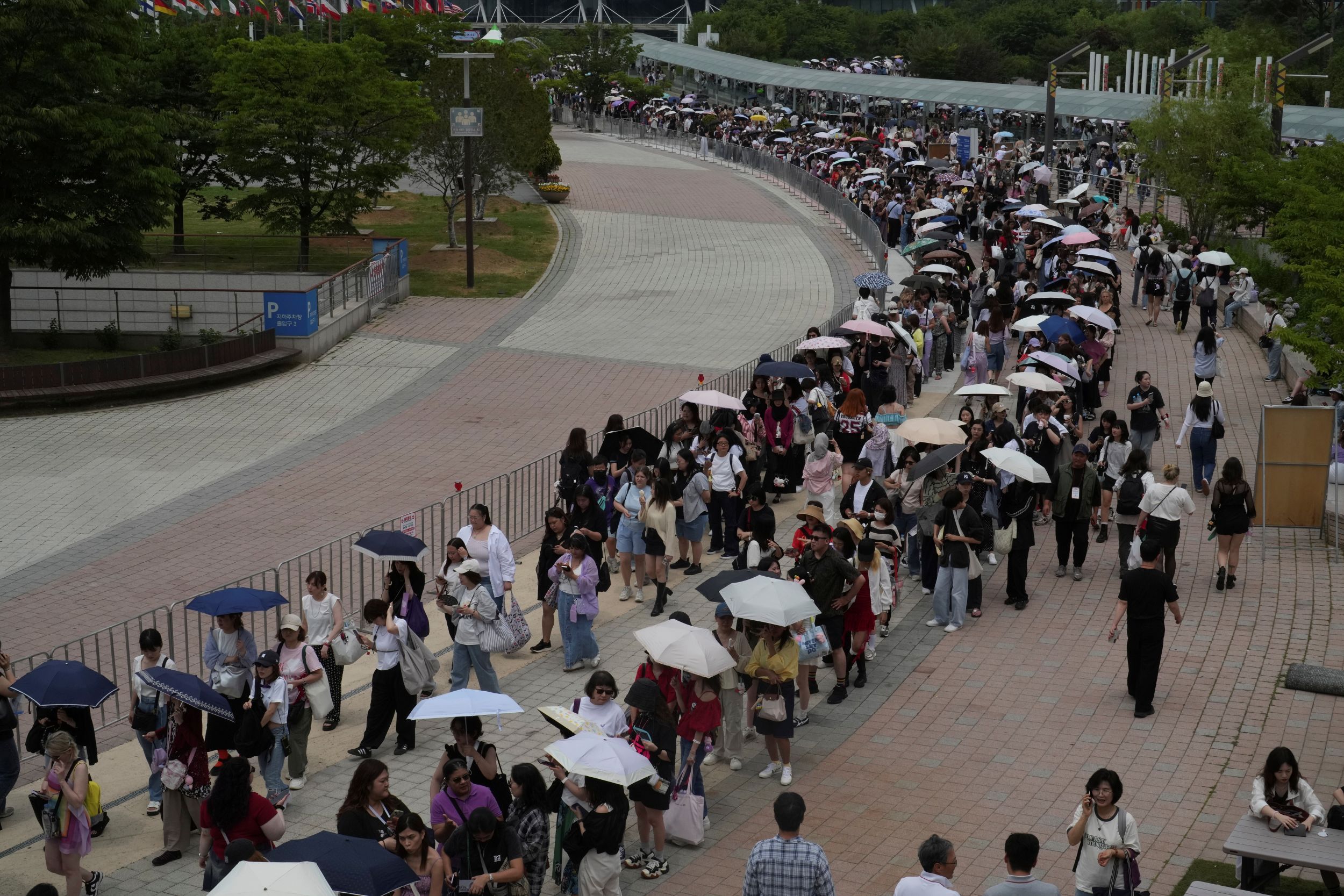 大批喜愛南韓知名男團BTS粉絲排隊等待進入演唱會現場。（美聯社）