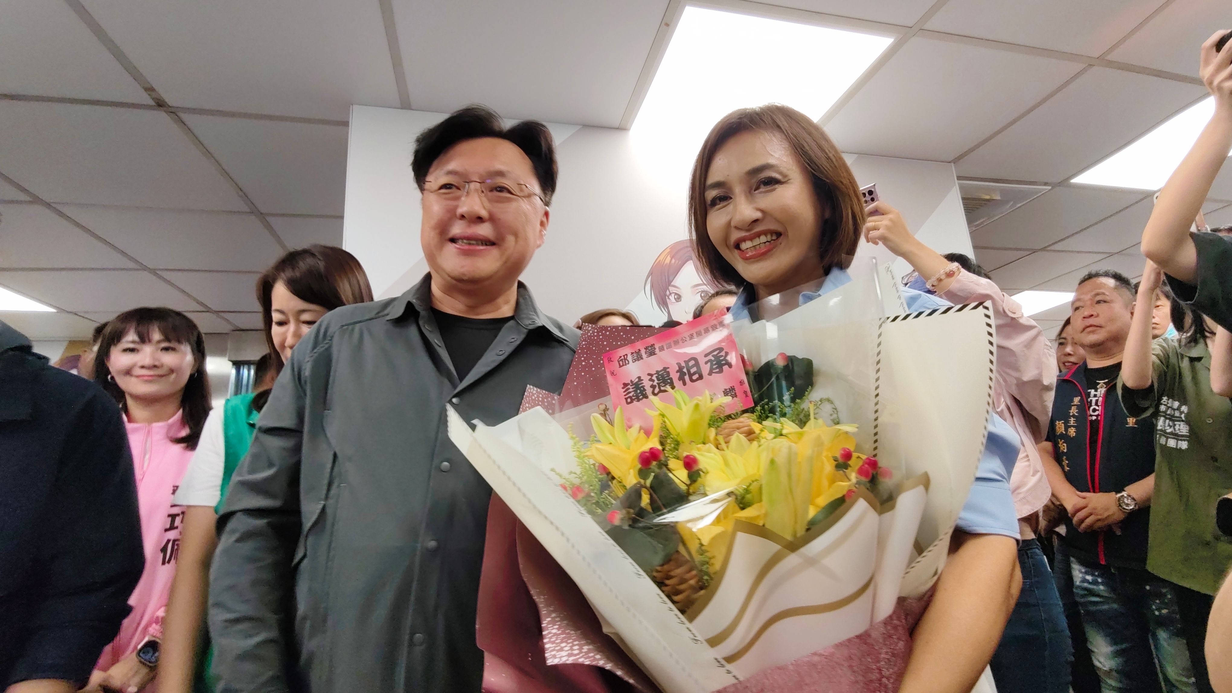 立委邱議瑩初選競選辦公室今成立，湧言會總幹事趙天麟手捧「議邁相承」祝福語的鮮花，以神秘嘉賓現身力挺。（圖/徐炳文攝）