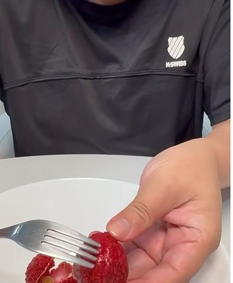 荔枝剝殼方法2：雙手拇指與食指分別放在底部一條明顯縫隙的兩側，輕鬆一擠就能剝開。（圖／翻攝自章新漫談YouTube）