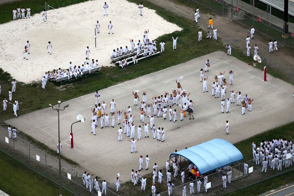 2025年7月4日。在邁阿密的移民拘留中心Krome Detention Center，被拘留者排出SOS的字樣並向直升機揮手。（AP）