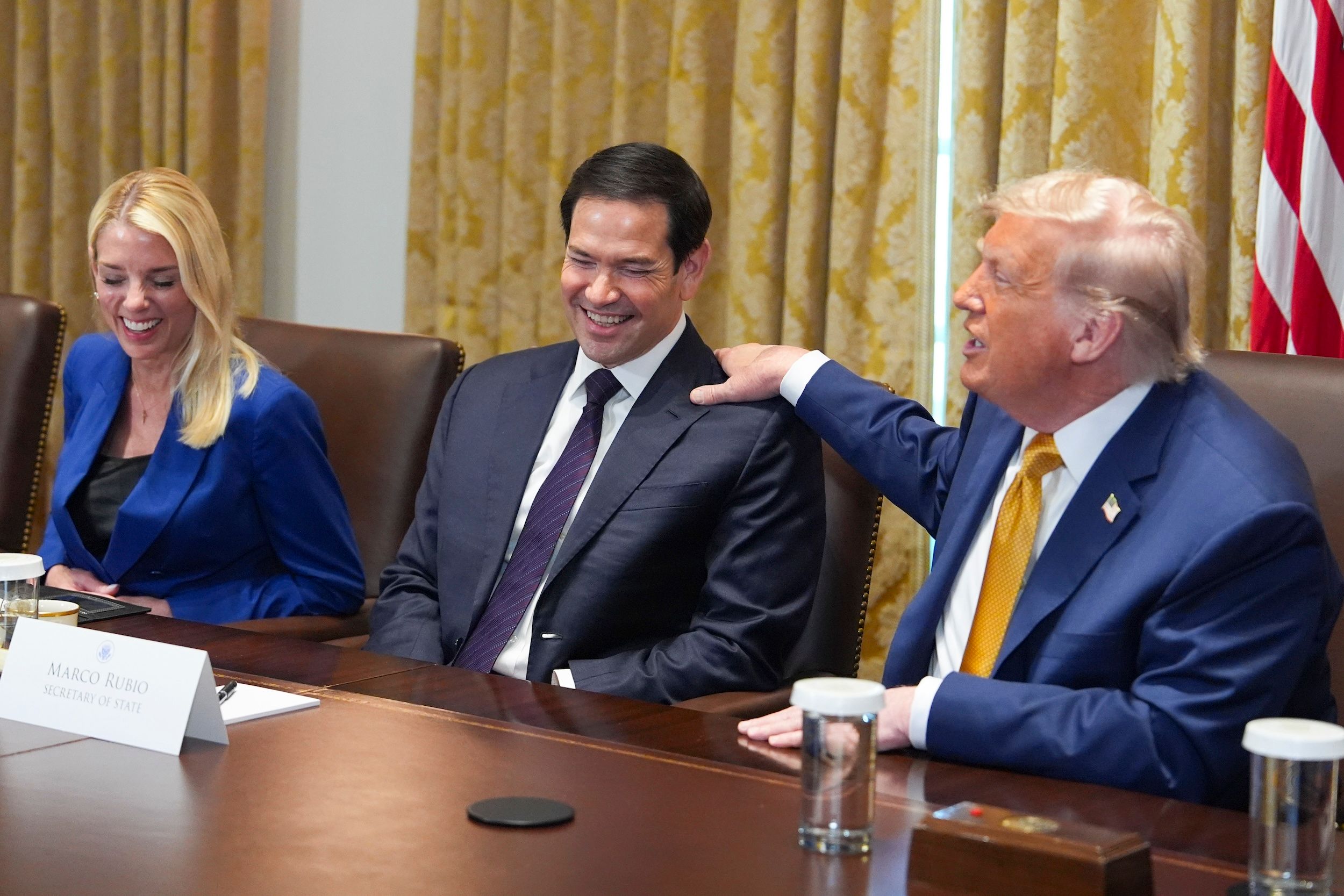 2025年7月8日、米国大統領トランプ（右）はホワイトハウスの内閣会議で国務省長官ルビオの肩をたたいた。（AP通信）