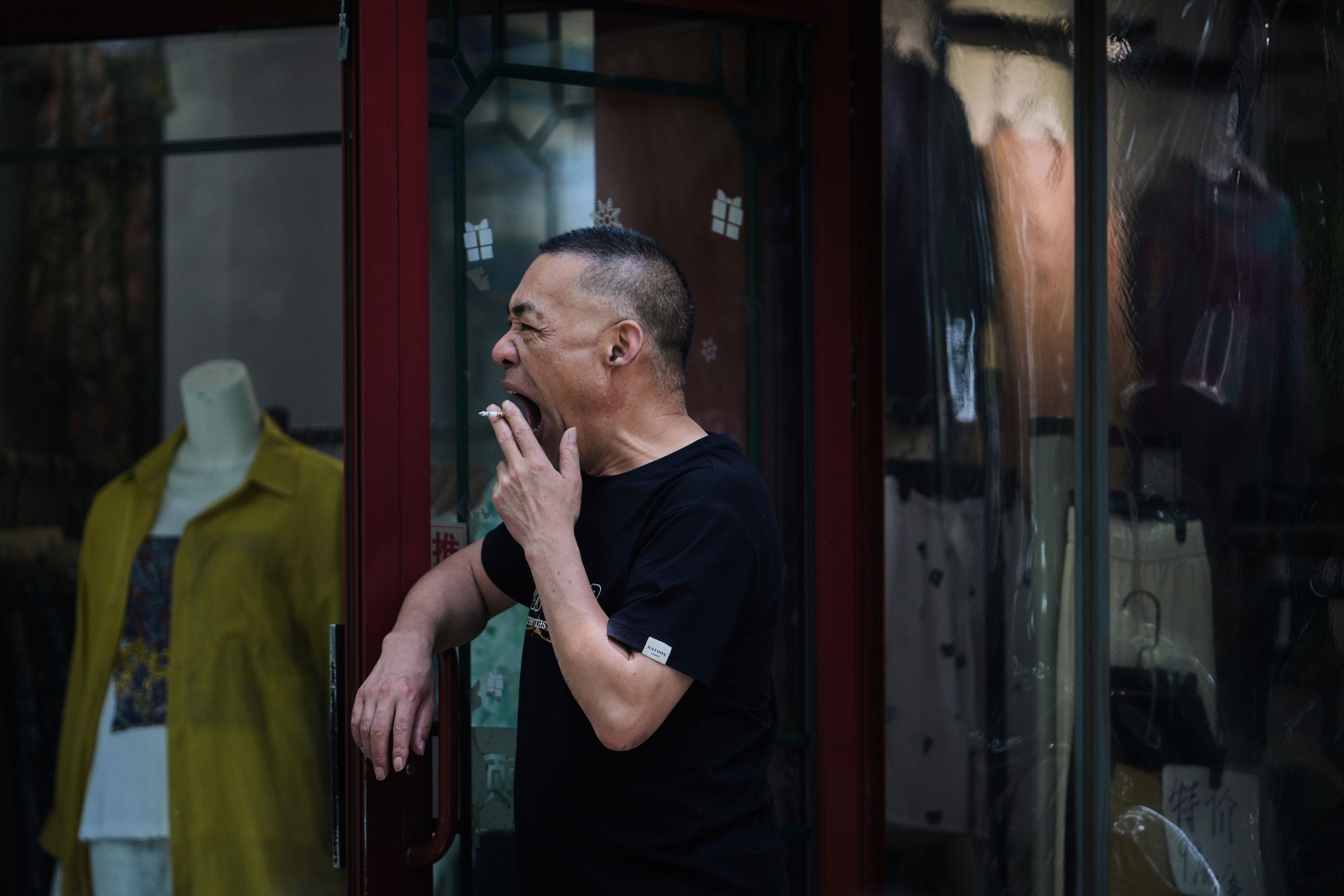 2025年7月15日，中國北京市民在路邊抽菸、打哈欠。(AP)