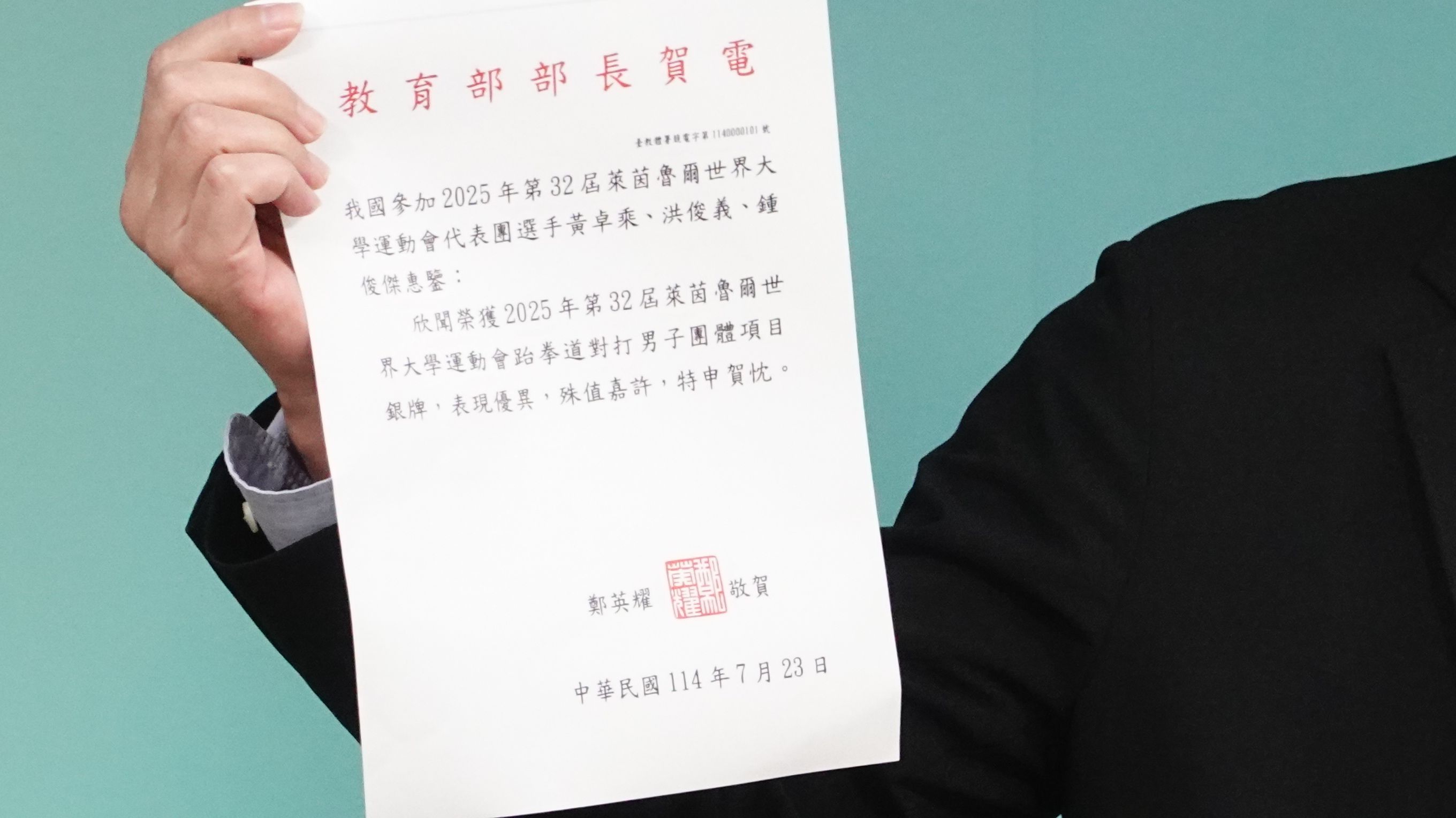 陸委會副主委梁文傑出示我方派發的世大運選手奪牌賀電。（楊騰凱攝）