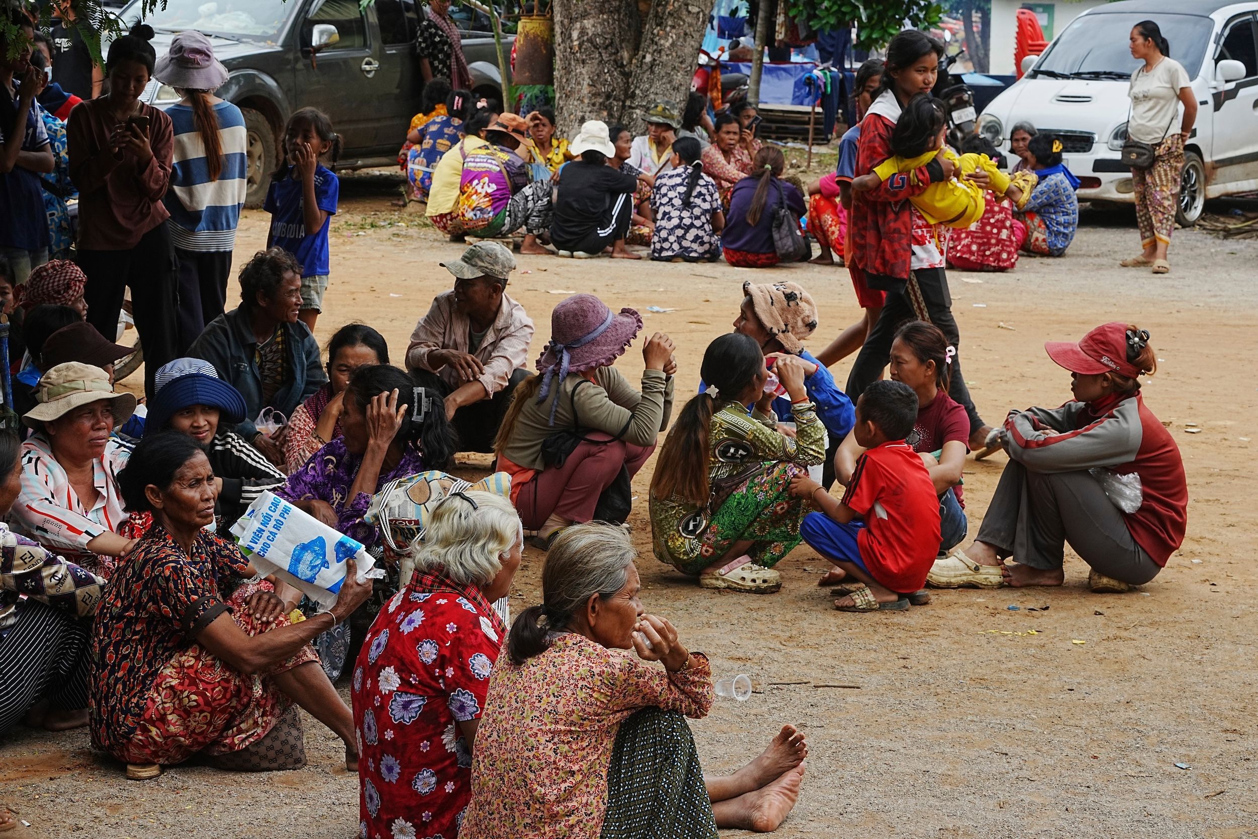 2025年7月27日，泰柬兩軍交戰之際，柬埔寨奧多棉吉省金邊寺一帶的村民正在等待領取慈善機構捐贈的難民物資。（美聯社）
