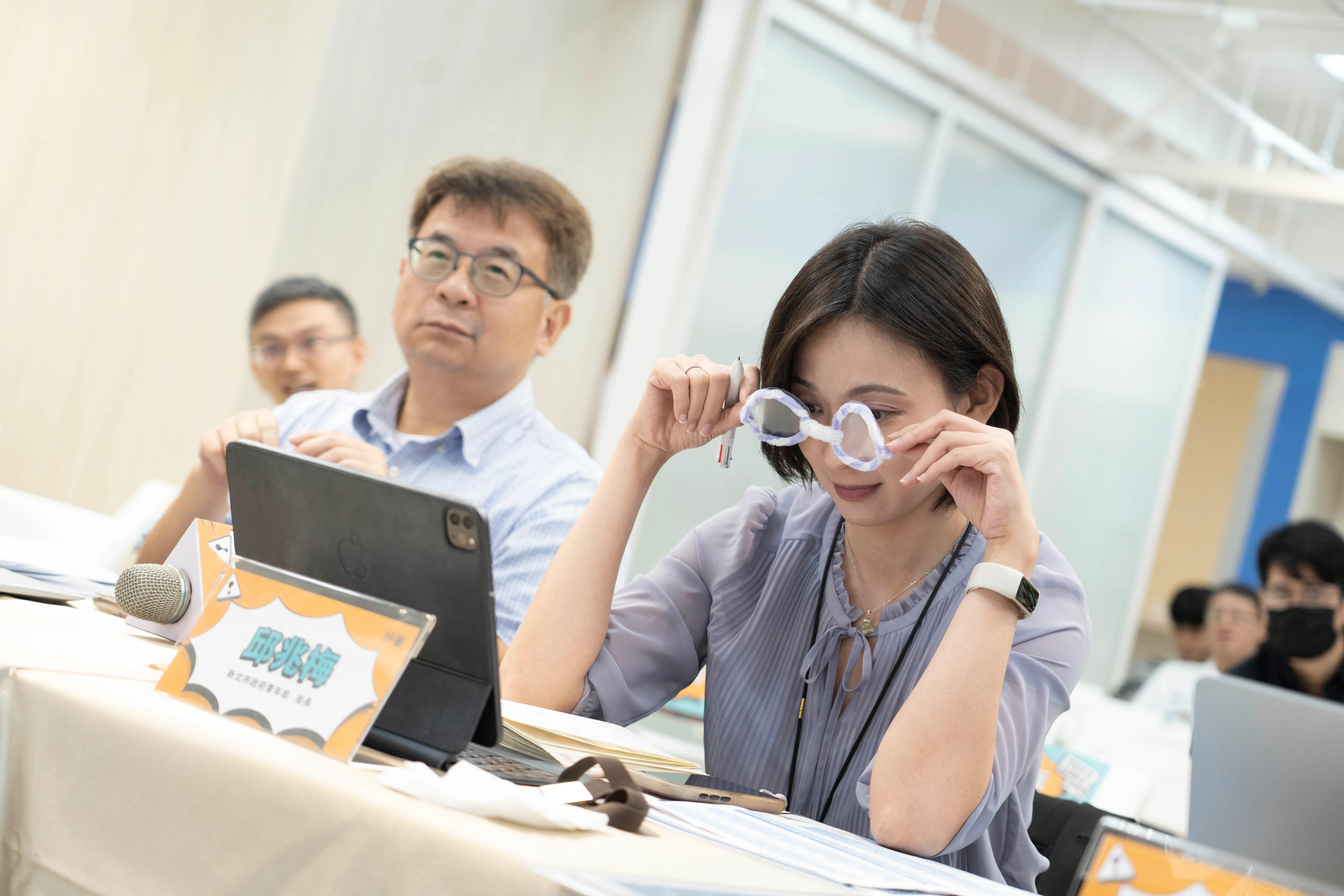 青年局長邱兆梅(右)戴上學員製作的老花眼鏡，體驗銀髮族視力模糊情境。(圖/新北市青年局提供)