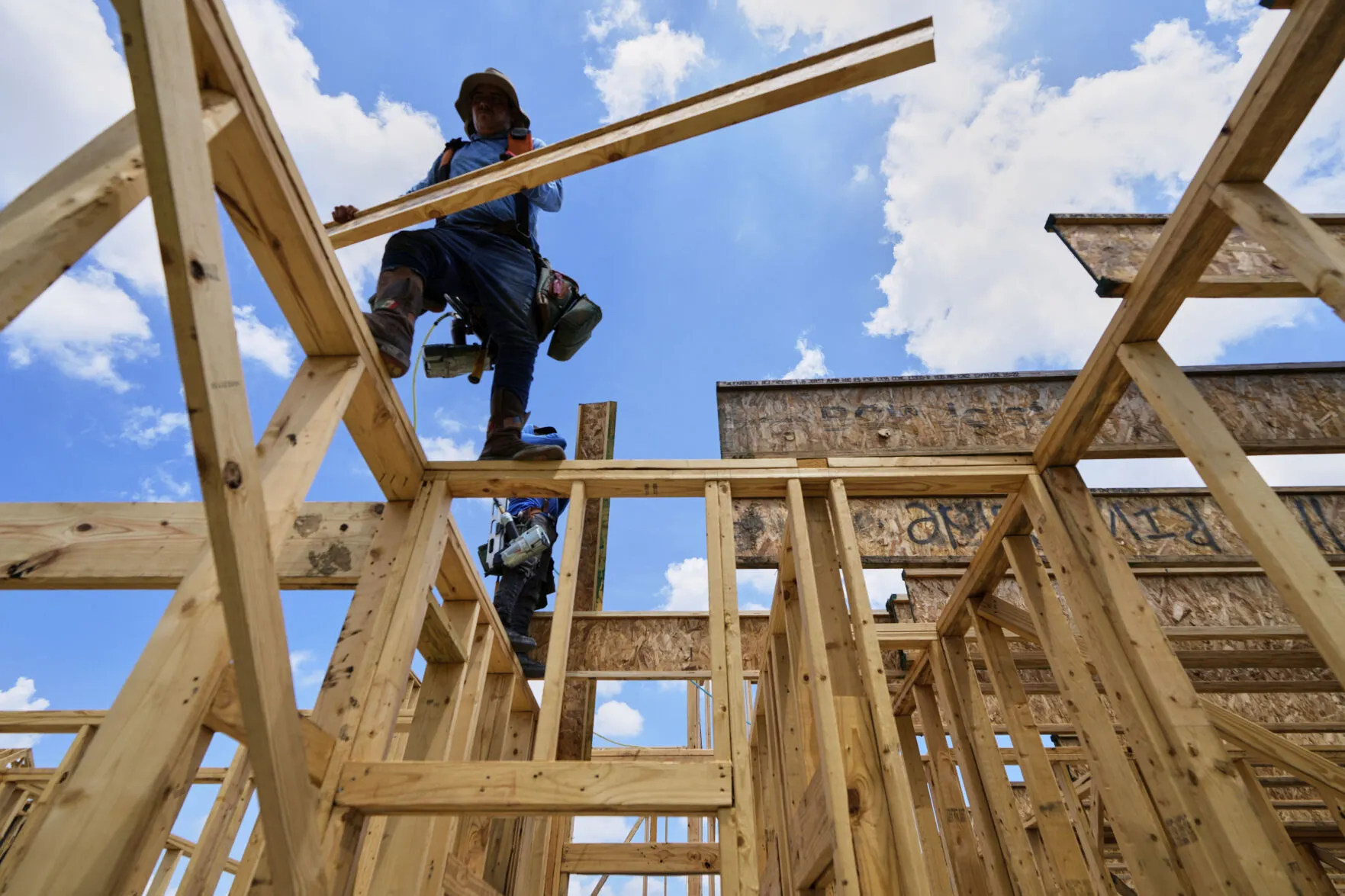 2025年7月15日。德州一名建築工人正在搬運材料。（AP）